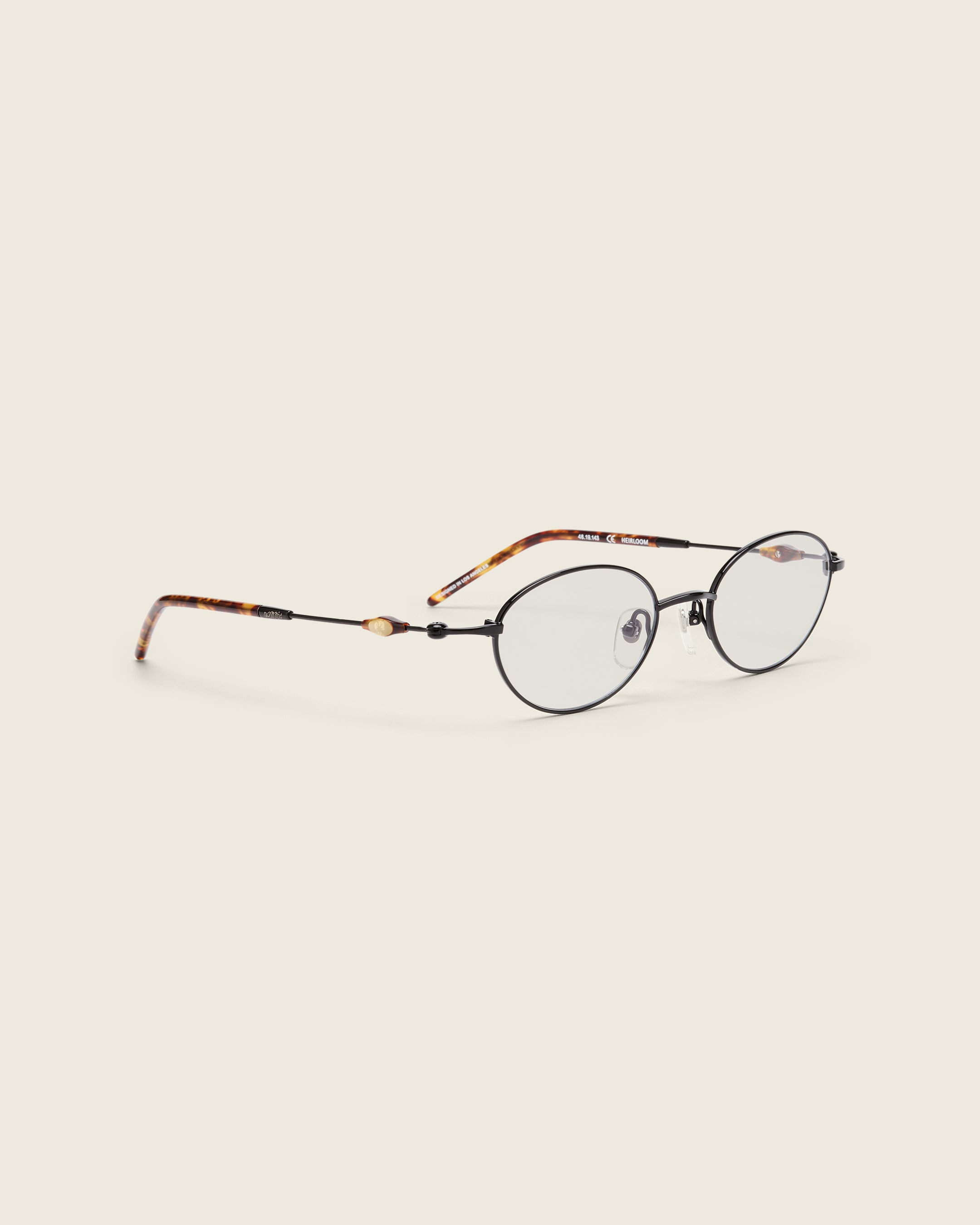 Slim, oval black titanium frames with adjustable nose pads and lightweight acetate arm temple. Quarter view.