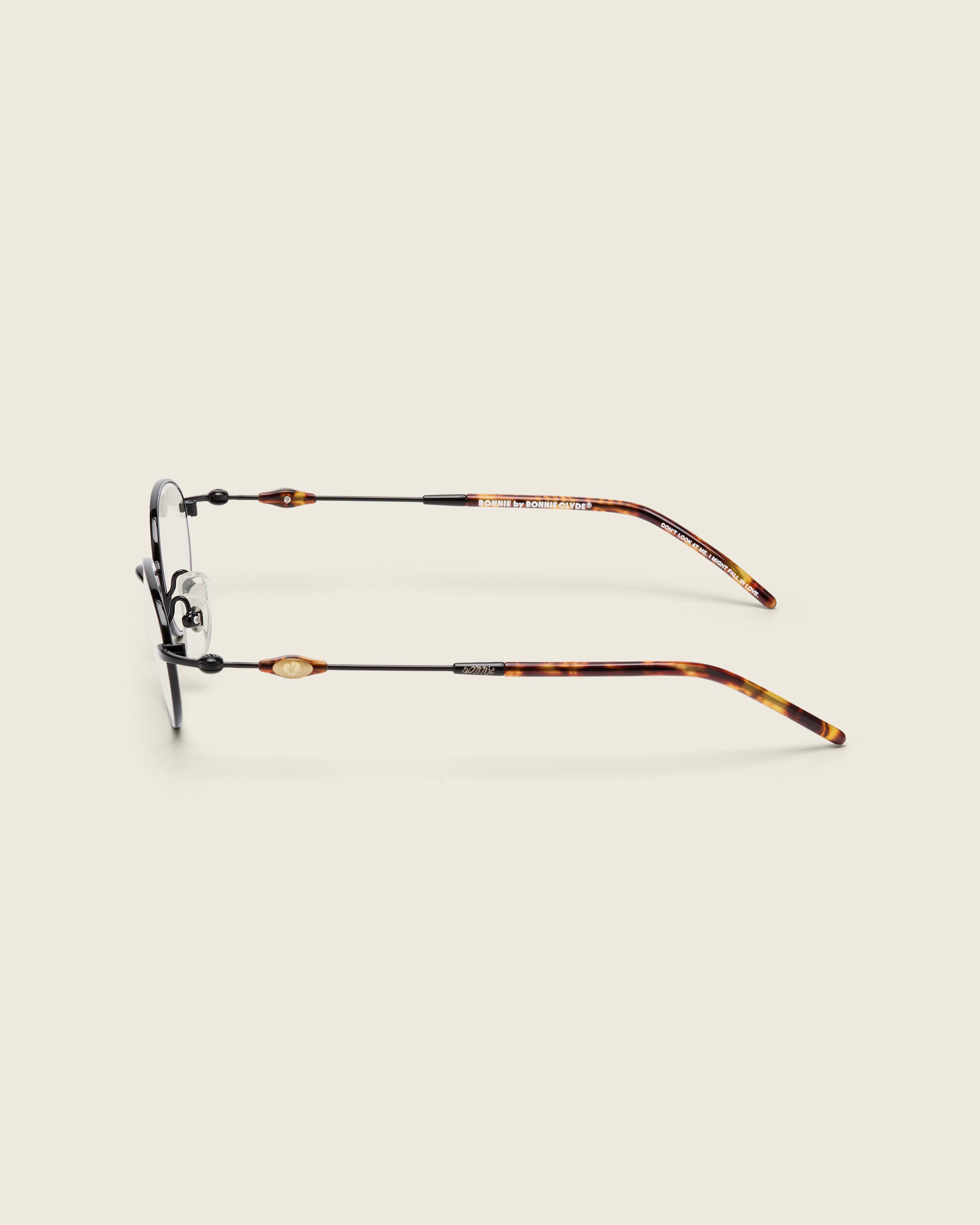 Slim, oval black titanium frames with adjustable nose pads and lightweight acetate arm temple. Side view.